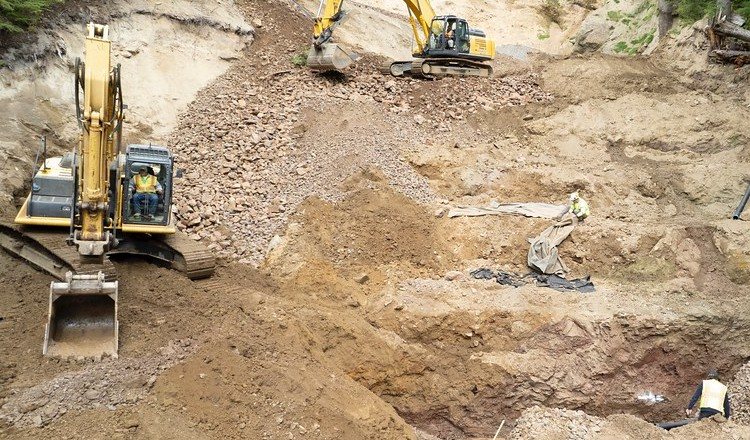 Excavators rebuilding a slip-affected slope